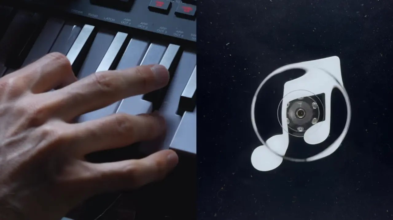 Apple Music Rebrand: The Logo Made by Sound 3 A hand on a keyboard beside the new white note-shaped Apple Music icon on black