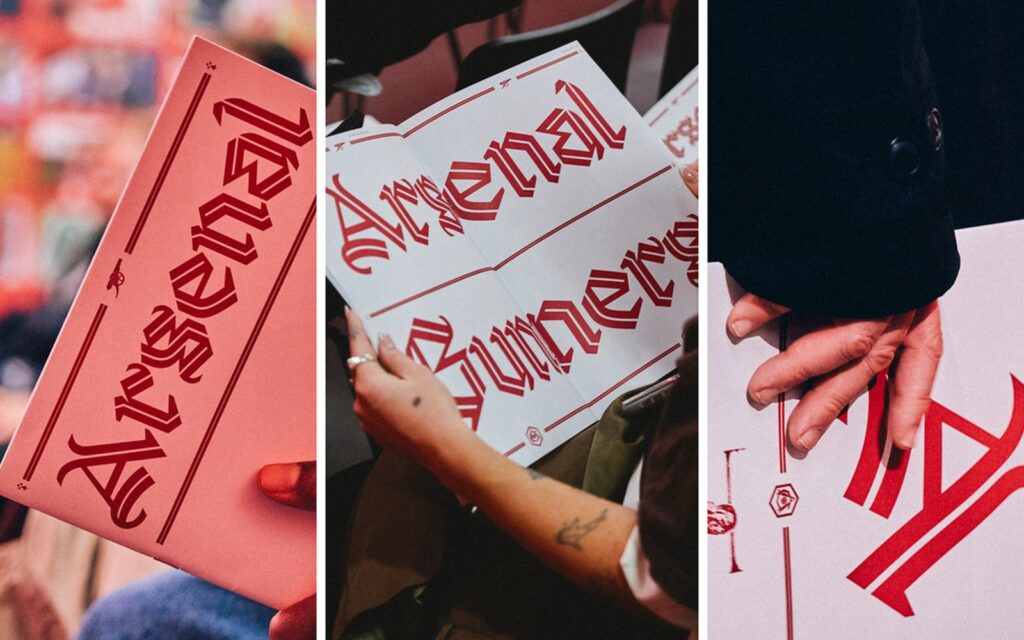 Fans holding cards printed with Arsenal lettering in the Rocastle blackletter