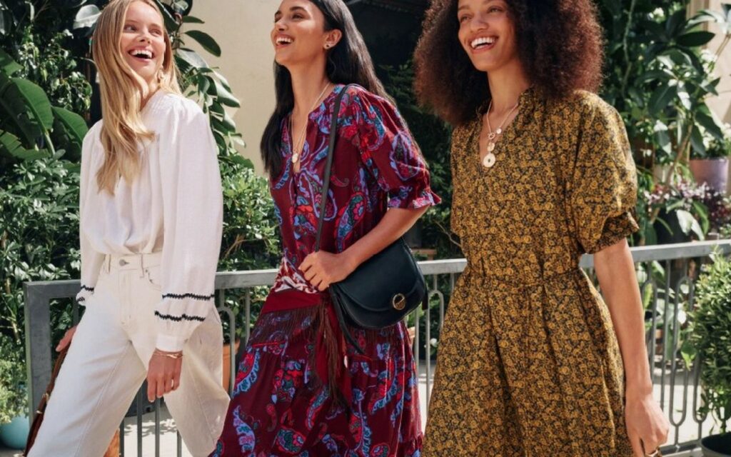 Three women in printed dresses and a white blouse from Walmart's Scenario launch collection
